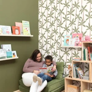 white botanical wallpaper and wall with armchair and toys