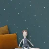 blue spotted wallpaper and wall with cushion and toys