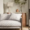 neutral spotted sofa with side table and lamps