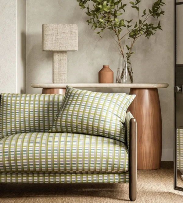 Charnwood Fabric - Evergreen by green striped sofa with side table and lamps