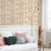 orange botanical wallpaper and wall with bed and cushion