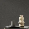 black-grey plain wallpaper and wall with armchair and side table