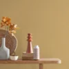yellow plain wallpaper and wall with side table and vases