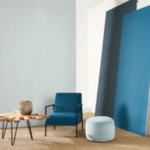 blue plain wallpaper and wall with armchair and pouf