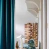 green botanical sofa with curtain and lamps