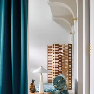 green botanical sofa with curtain and lamps