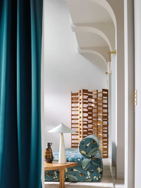 Astelia Fabric - Topaze by green botanical sofa with curtain and lamps