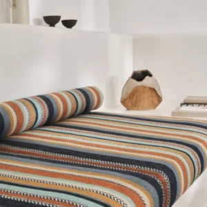 orange striped bed with cushion and vases