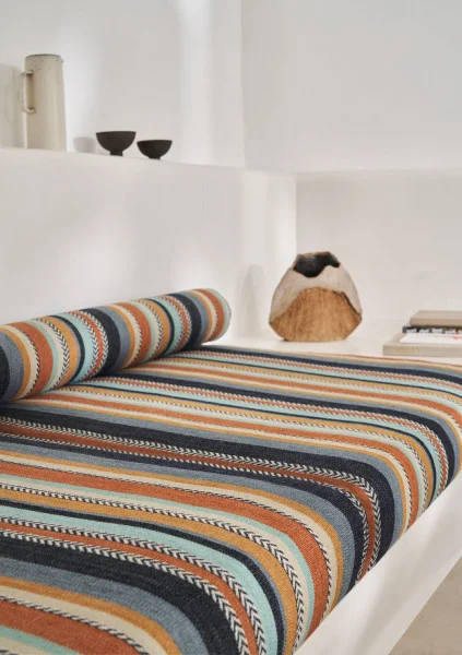 Costa Nova Fabric - Celadon Moutarde by orange striped bed with cushion and vases