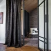 black-grey geometric curtain with armchair and vases