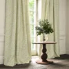 yellow botanical curtain with cushion and vases