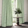 green botanical curtain with cushion and vases