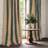 blue striped curtain with side table and vases