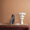orange plain wallpaper and wall with side table and vases
