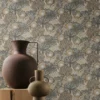 green botanical wallpaper and wall with armchair and vases