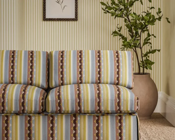 Lutley Stripe Fabric - Damson / Medlar by red striped sofa with plants