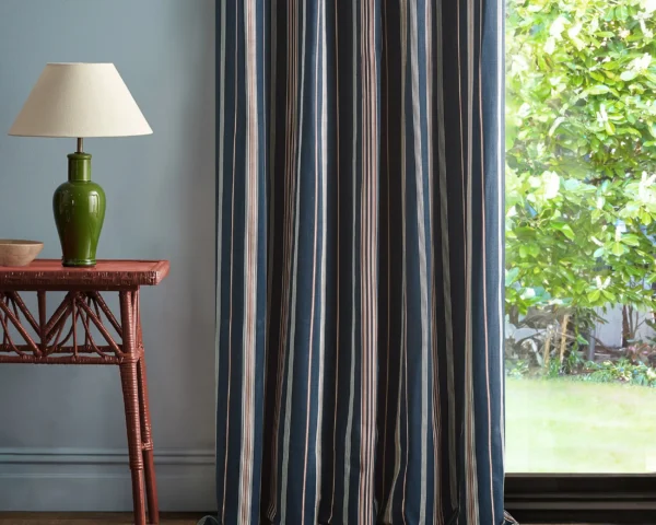 Latimer Stripe Fabric - Indigo / Madder by blue striped curtain with side table and lamps