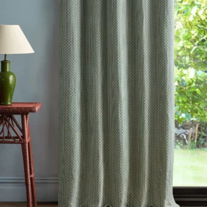 green geometric curtain with side table and lamps
