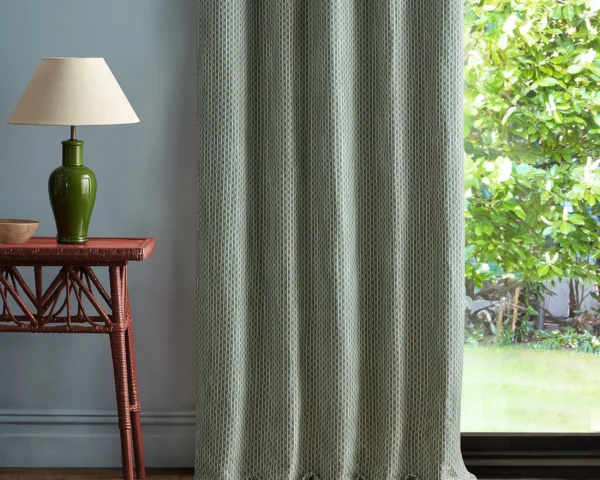 green geometric curtain with side table and lamps