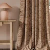 orange botanical curtain with side table and lamps