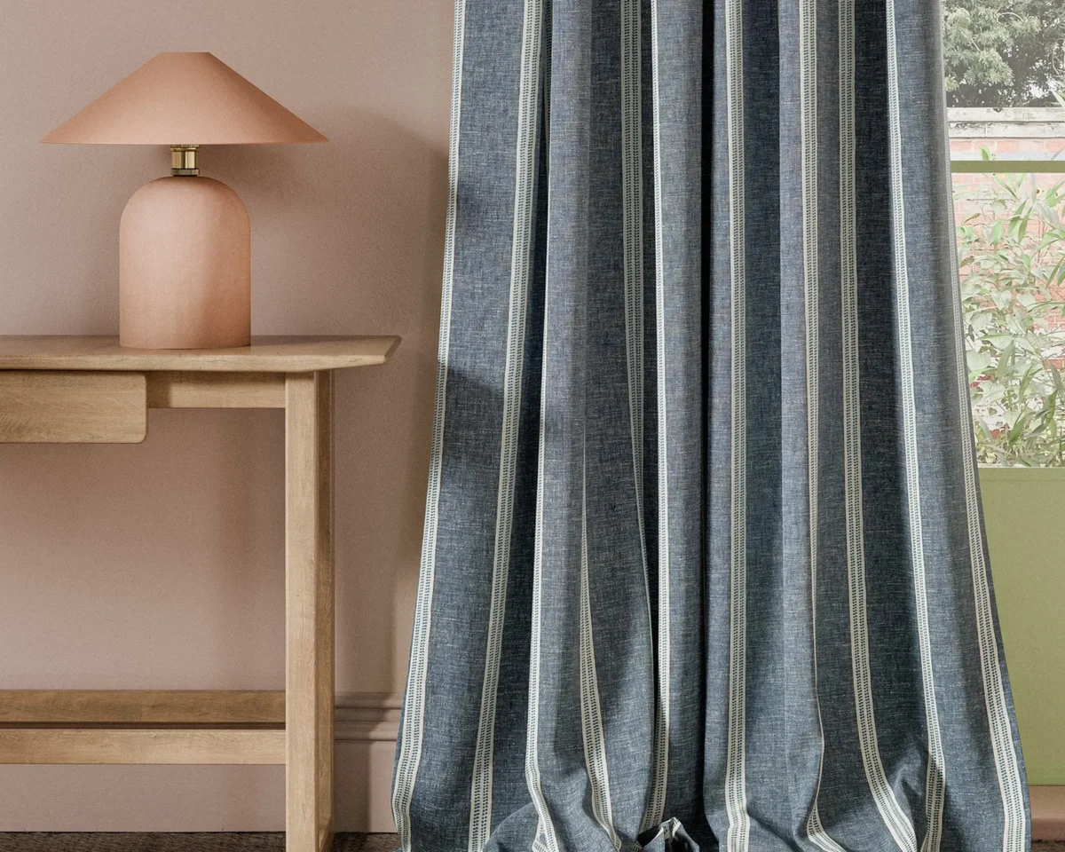 Ordo Fabric - Ink by blue striped curtain with side table and lamps
