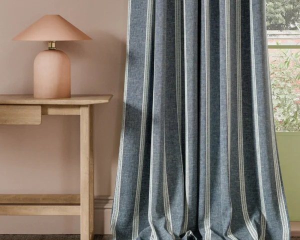 Ordo Fabric - Ink by blue striped curtain with side table and lamps