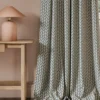 blue geometric curtain with side table and lamps