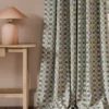 blue geometric curtain with side table and lamps
