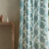 blue botanical curtain with side table and vases