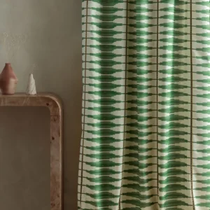green striped curtain with side table and vases