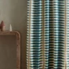 blue striped curtain with side table and vases