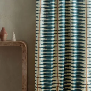 blue striped curtain with side table and vases