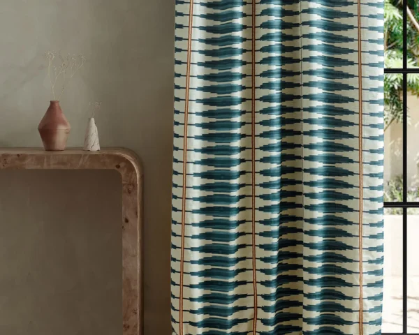blue striped curtain with side table and vases