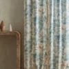 blue botanical curtain with side table and vases