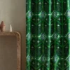 green geometric curtain with side table and vases