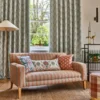 green striped sofa with curtain and cushion