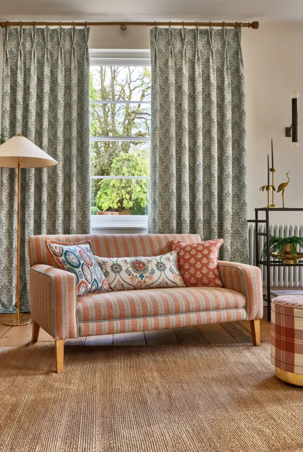 green striped sofa with curtain and cushion