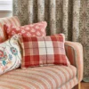 green checked sofa with cushion and curtain