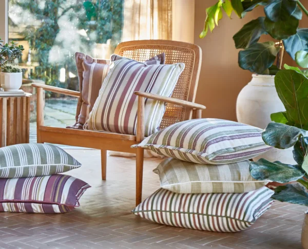 Leonardo Fabric - Sienna by red striped blind with plants and vases